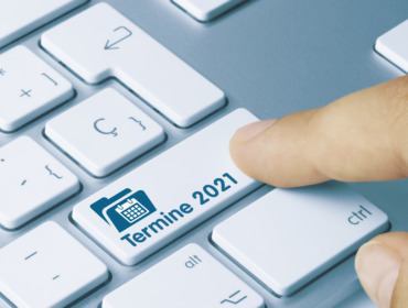 Termine 2021 Written on Blue Key of Metallic Keyboard. Finger pressing key.